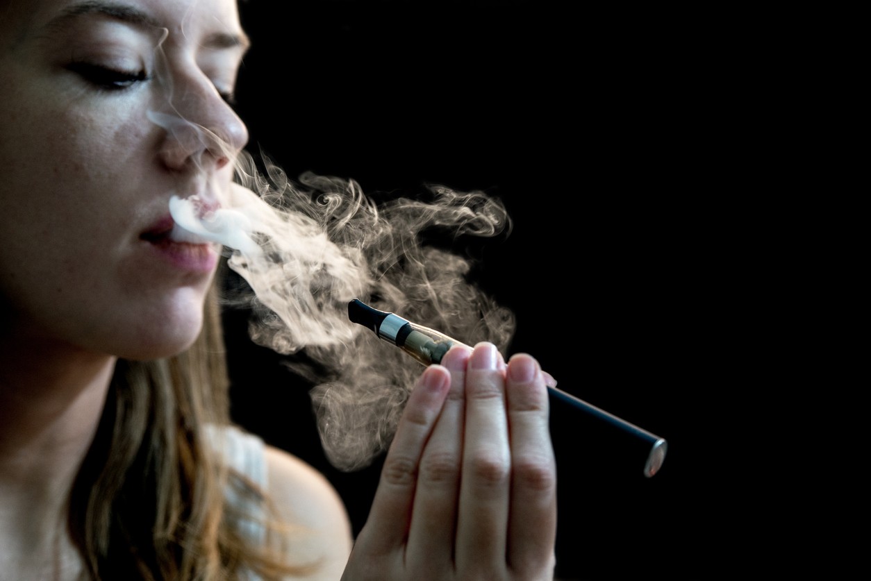 Close up of a woman inhaling from an electronic cigarette