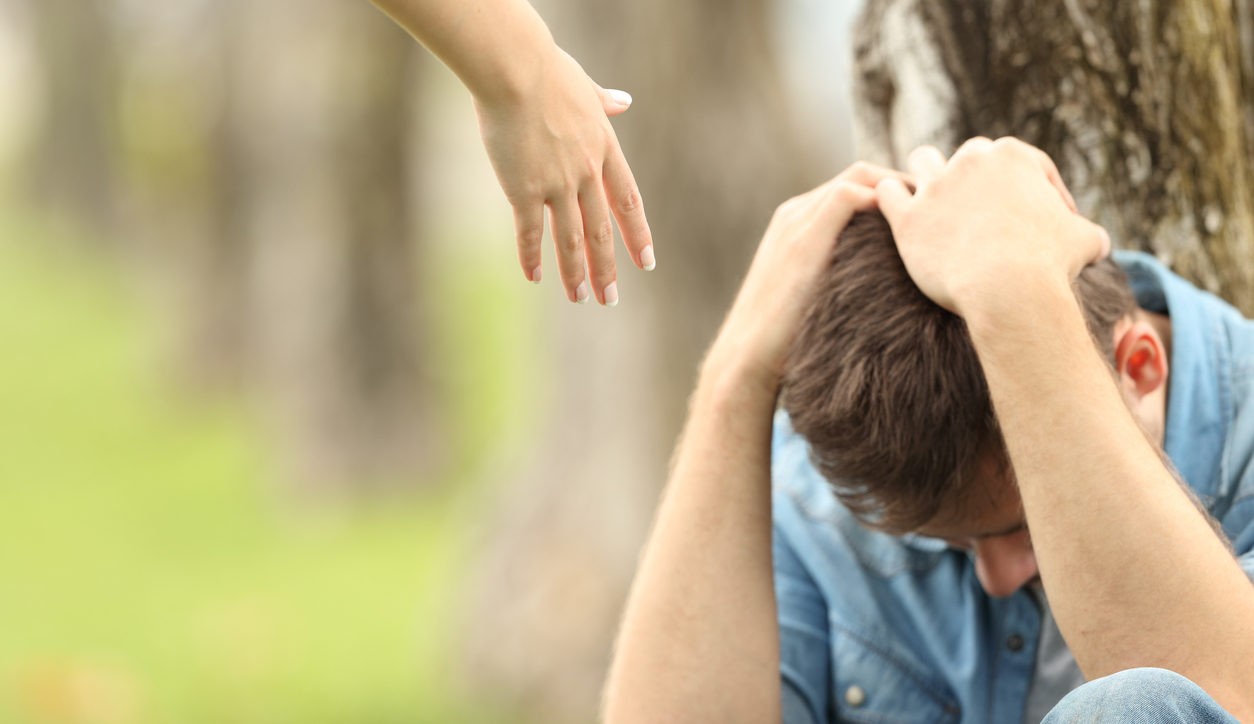 Sad teen and a hand offering help