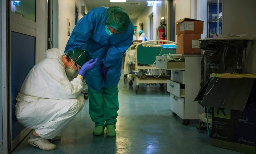 x90717893_AFP-PICTURES-OF-THE-YEAR-2020A-nurse-wearing-protective-mask-and-gear-comforts-anot.jpg.pagespeed.ic.I7s0zcGAkx