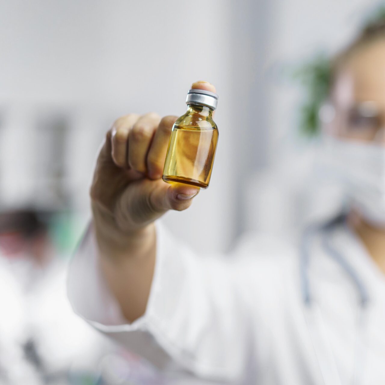 front-view-defocused-female-researcher-with-vaccine-bottle